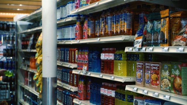 在杂货店或超市货架上的果汁和运动饮料瓶子的近角。食物。视频素材