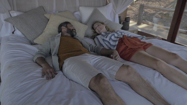 一对夫妇在南非的豪华床上休息，慢镜头视频下载