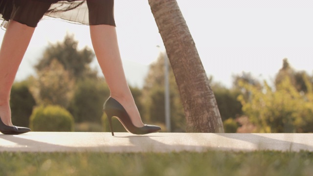 一个漂亮的女人穿着高跟鞋走路，突然她的脚扭伤了视频素材