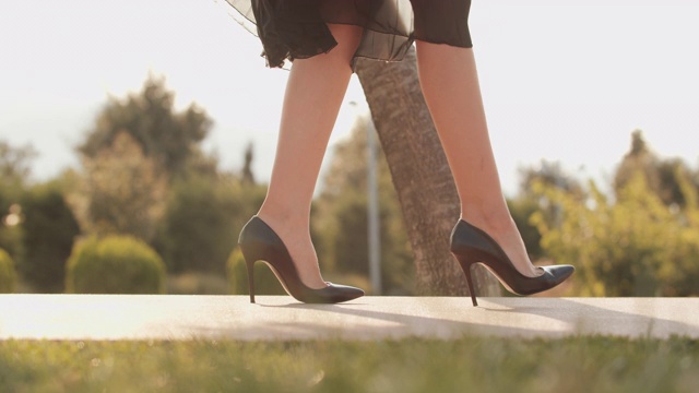 一个漂亮的女人穿着高跟鞋走路，突然她的脚扭伤了视频素材
