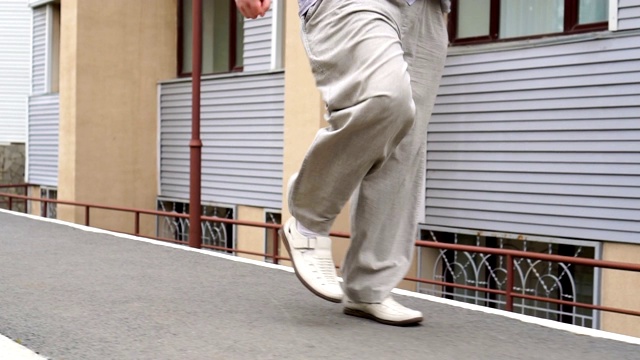 穿着白鞋的男人腿在户外瓷砖路上奔跑视频素材