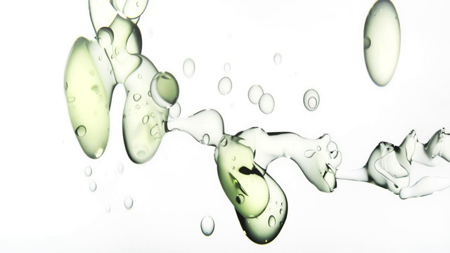 近距离和缓慢的运动，清澈的油液倒入水从右边变成大气泡漂浮在白色的背景视频素材