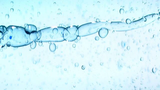 油创造了一排气泡，而扭曲的蓝色色调的水与小气泡弹跳周围的背景视频素材