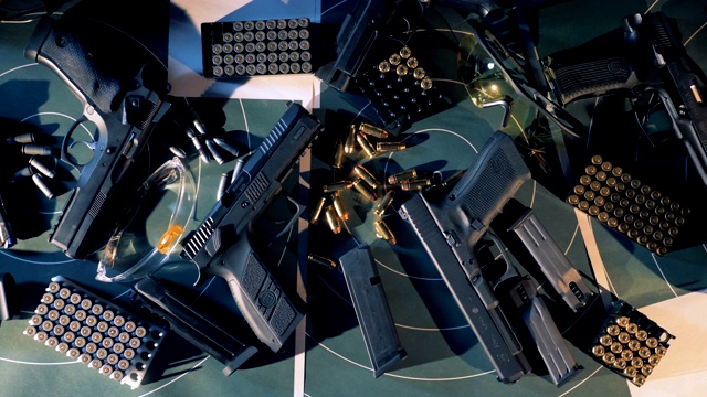 在射击室的桌子上放着带子弹的枪。4 k视频下载