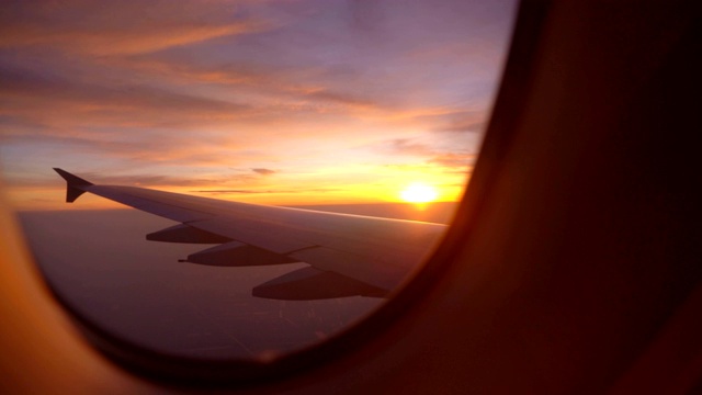 在早晨看着飞机的窗户和美丽多彩的天空视频素材