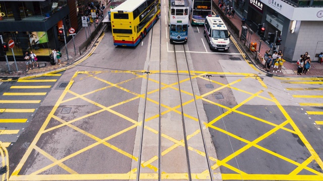 4K时间镜头，一群交通车辆和行人正穿过香港中区黄色人行横道视频素材