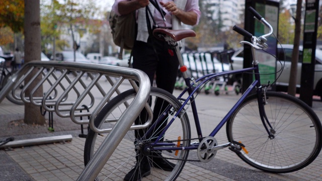 拉丁美洲商人停车，把自行车锁在车站停车场视频下载