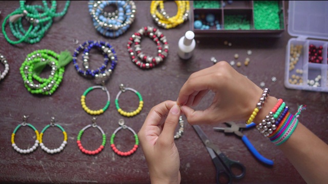 女性的手用小球和石头制作手工珠宝视频素材