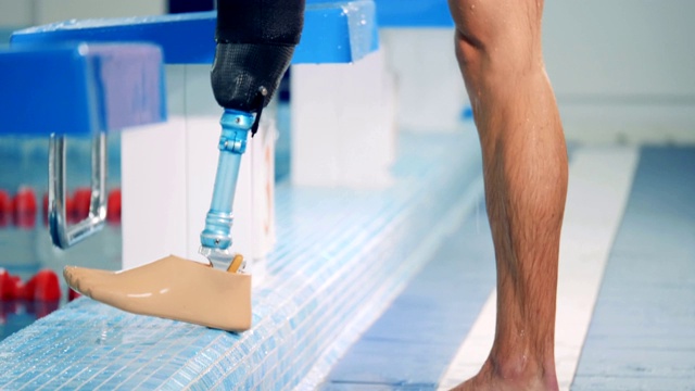 游泳者在泳池训练中戴仿生假肢，假腿。视频下载