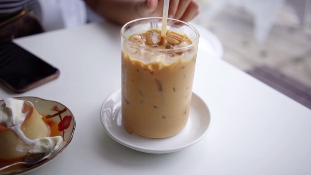 手搅拌美味的冰咖啡。视频下载