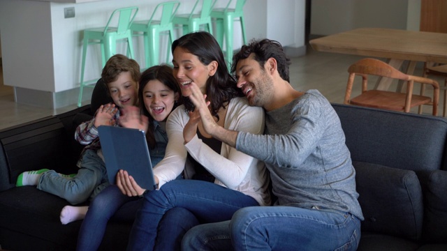 快乐的母亲拿着平板电脑，每个人都在视频通话中微笑着打招呼视频下载