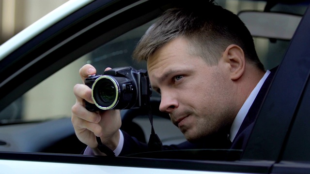 男特工坐在车里偷拍，摄影新闻视频素材