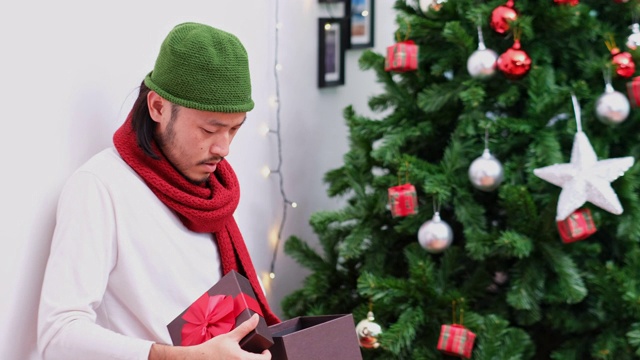 年轻的亚洲男子打开圣诞礼盒失望的表情视频素材