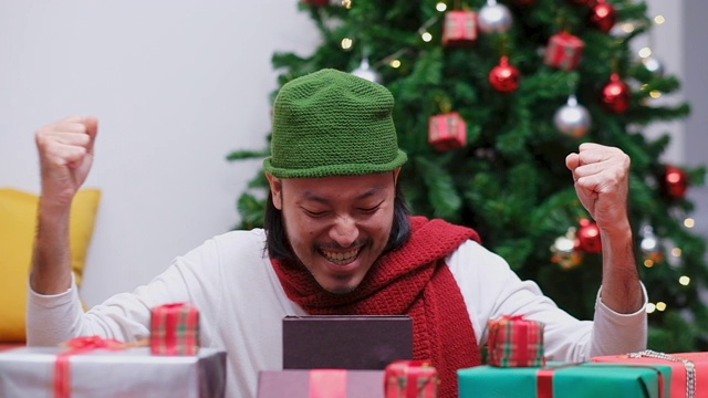 特写快乐的年轻亚洲人打开和惊喜的圣诞礼物，礼盒在庆祝派对，慢镜头视频购买
