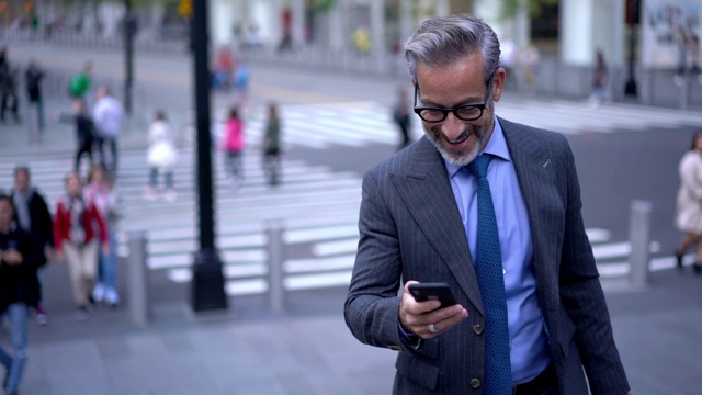成功男性企业家50多岁的男性通过手机在网站上阅读财经新闻，视频下载