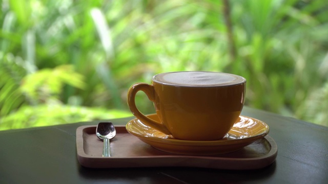 黄色的咖啡杯放在木桌上视频素材