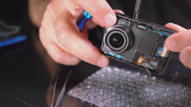 小型电子维修。特写视频的人的手维修一个行动摄像机。视频素材