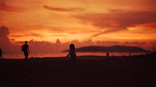 小女孩在海滩上欣赏日落视频素材