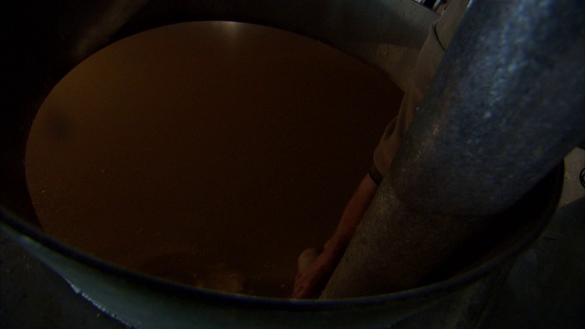 一只手在一个大碗里装满一瓶发酵的玉米。视频下载