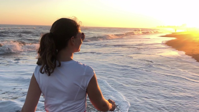 女人在海滩散步沉思冥想视频素材
