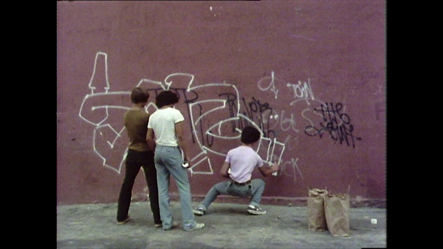 涂鸦艺术家在一面红墙上画草图;1976年视频下载