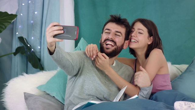 一对快乐的情侣一边自拍一边做鬼脸视频素材