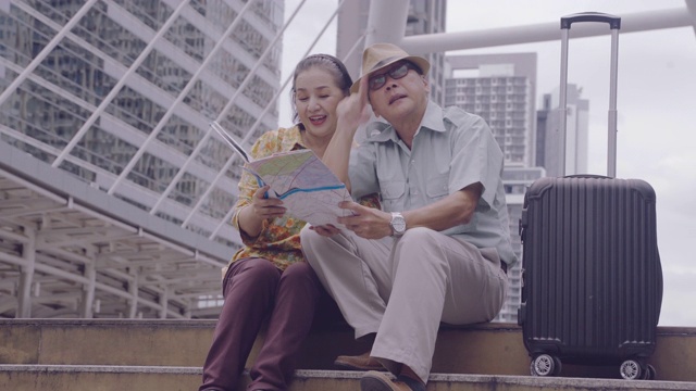 亚洲老年夫妇拿着地图搜索泰国的目的地街道，退休年龄的老年人用自己的储蓄旅行，旅行者和生活方式的老概念视频素材