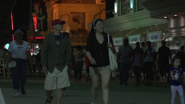 行人在晚上沿着街道走。视频下载