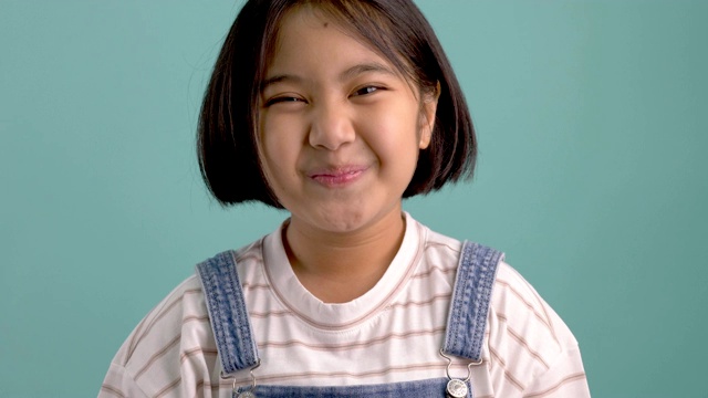 慢镜头快乐的亚洲女孩在绿色屏幕前微笑和大笑视频下载
