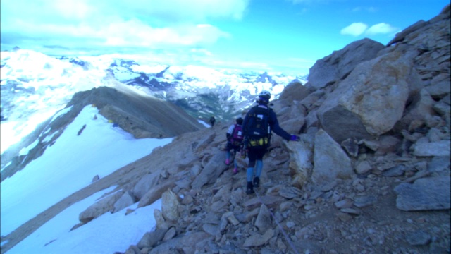 徒步旅行者穿越险峻的山脊。视频下载