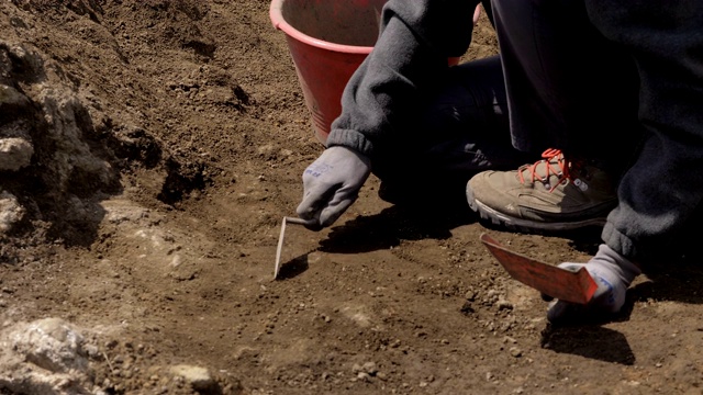 考古学家双手使用工具挖掘考古遗址视频素材