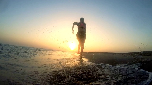慢跑在日落之后。沙滩假日视频素材