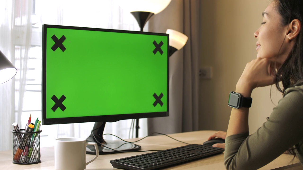 女人在家使用电脑的绿色屏幕视频素材