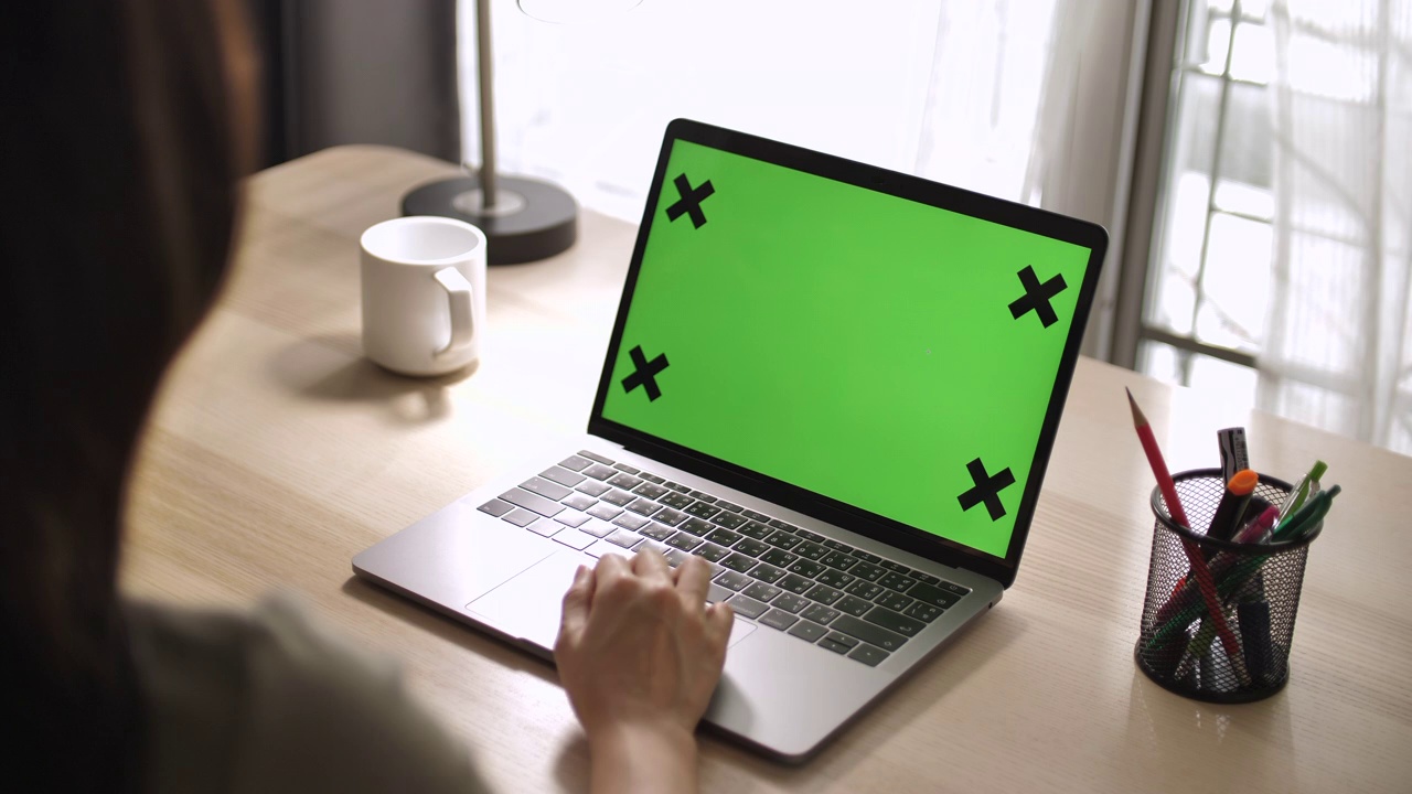 亚洲妇女使用带有绿色模拟屏幕的笔记本电脑，而坐在桌前视频下载