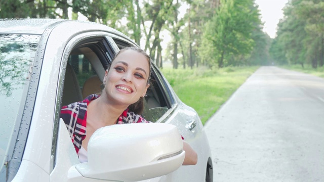 年轻女子坐在她的车里，环顾乡间的道路视频素材
