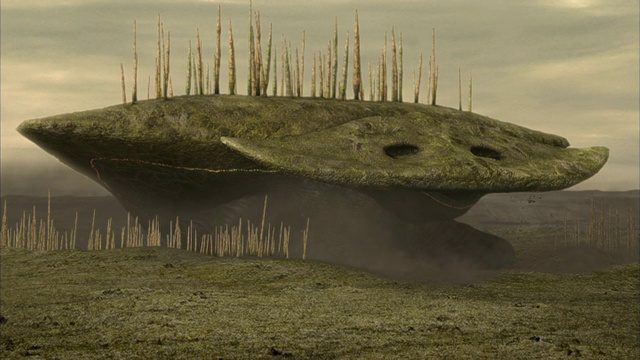 巨大的生物背上长着树，从土壤中冒出来，走在一个外星星球的地形上。视频下载