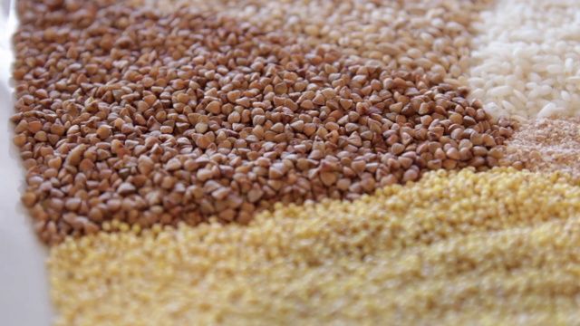 在一个盘子里放好几种麦片。荞麦，大米，小米，大麦，藜麦。特写镜头。视频下载