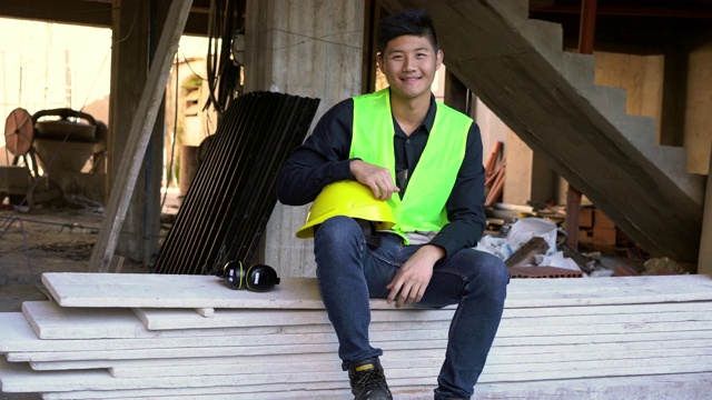 微笑的年轻建筑承包商坐在木板上视频素材