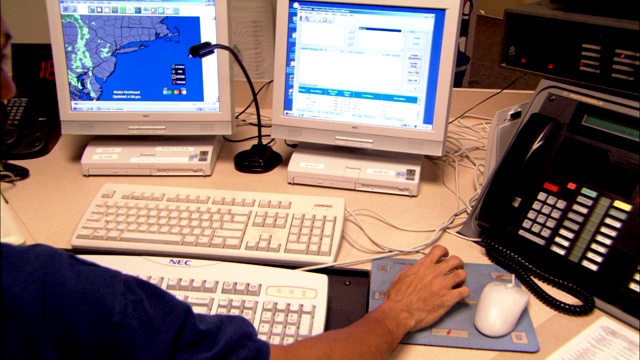 一个男人在一个装满电脑设备的控制室工作。视频素材