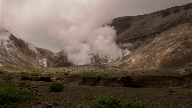 在shikotsutoya国家公园，一团雾状的气体云从包围着臼山的地面上逃逸出来。视频素材
