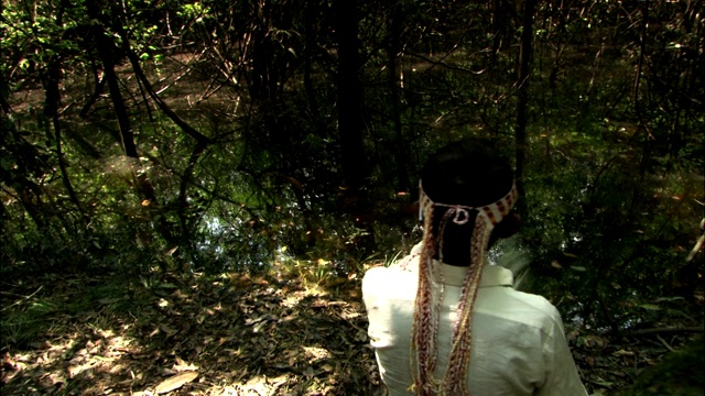 在亚马逊雨林，一位萨满在一条蟒蛇陷阱旁边举行仪式。视频下载
