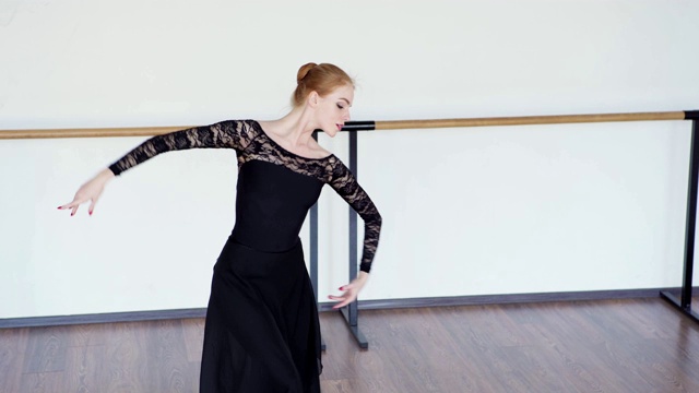 倾斜下中镜头优雅的女芭蕾舞者在黑色蕾丝紧身衣和裹裙表演舞蹈排练视频下载