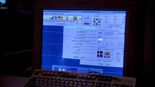 一名男子在一个电脑屏幕前工作，屏幕上显示着区域道路。视频下载