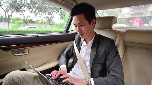 4K年轻商人在汽车后座上使用笔记本电脑视频素材