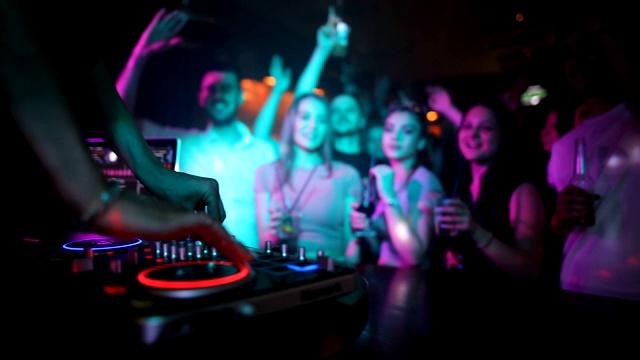 女DJ双手混音在唱盘上与年轻人跳舞的背景。她跳霹雳舞的时候舞厅里都是人视频素材