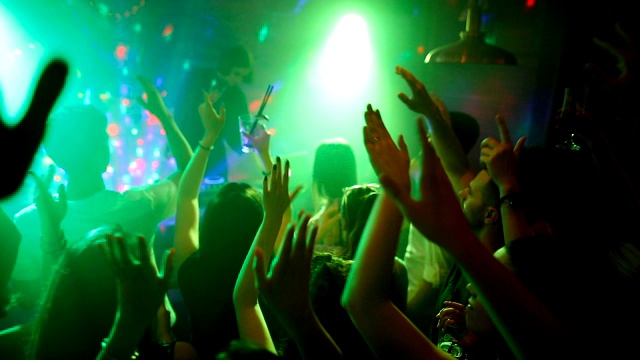 快乐的朋友与美丽的女DJ在舞台上举起手臂跳舞迪斯科视频素材