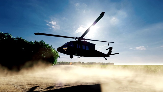 在一个晴朗的日子里，一架黑鹰军用直升机降落在一片荒芜地区的一条尘土飞扬的道路上。视频素材