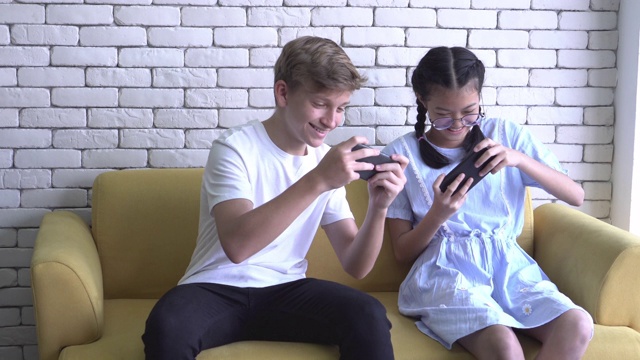 男孩和女孩在沙发上玩手机视频下载