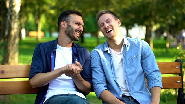 男性朋友在公园的长椅上谈笑风生，回忆着有趣的故事视频下载