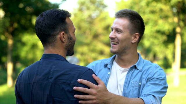 两个男性朋友突然在户外相遇并拥抱，心情愉悦视频下载